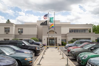 Exterior view of Spokane Veterans Home with flags and cars