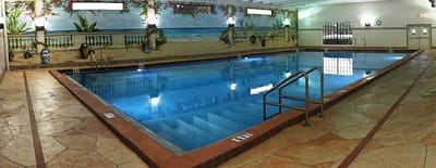 Indoor pool area with beach mural backdrop
