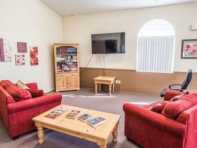 Cozy common area with red sofas and a television