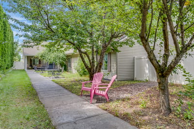 Outdoor space with pink chairs and trees