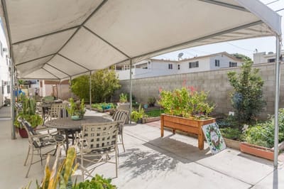 Covered outdoor patio area with garden beds