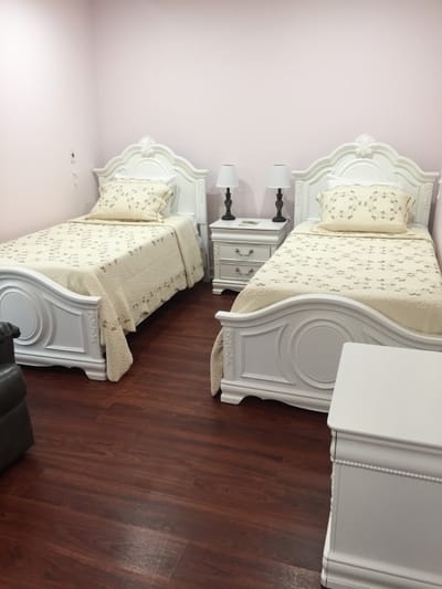 A shared resident room with two beds and bedside tables