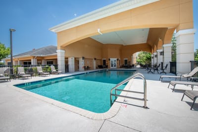 Pool area with lounge chairs under a covered cabana