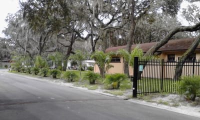 Exterior view of Pleasant Living Mobile Home Park with palm trees