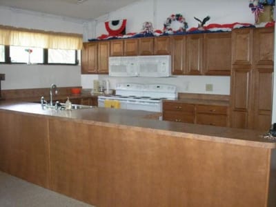 Bright kitchen area in a facility with cabinets and appliances