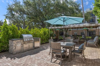 Outdoor seating area with grill and shaded umbrella