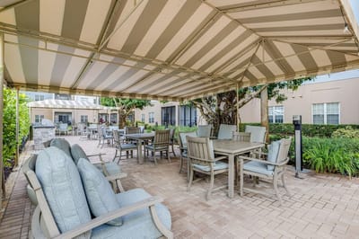 Outdoor shaded seating area with tables and chairs