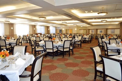 Dining room set up for a meal with flowers on tables