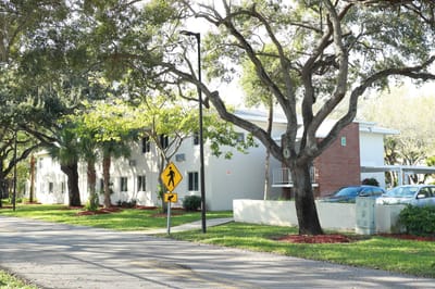 Exterior view of assisted living facility surrounded by greenery