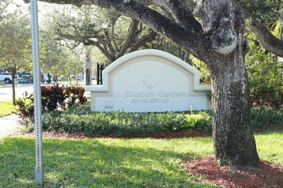 Exterior sign of St. Elizabeth Gardens with landscaping