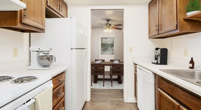 A well-lit kitchen area with dining in the background