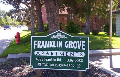 Sign for Franklin Grove Apartments with green landscaping