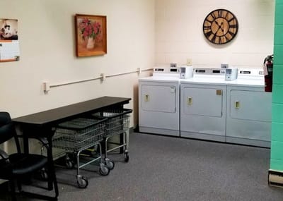 Laundry room with washers and a clock on the wall