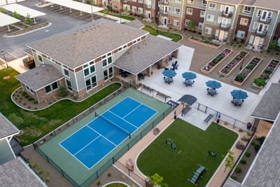 Aerial view of outdoor amenities including tennis courts and gardens