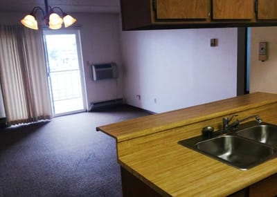 Interior view of a senior living apartment kitchen and living area