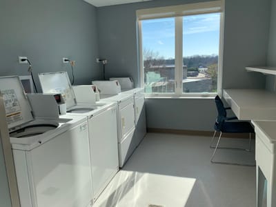 Laundry room with washing machines and bright window light