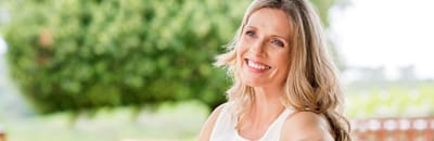 Smiling woman sitting outdoors in a garden