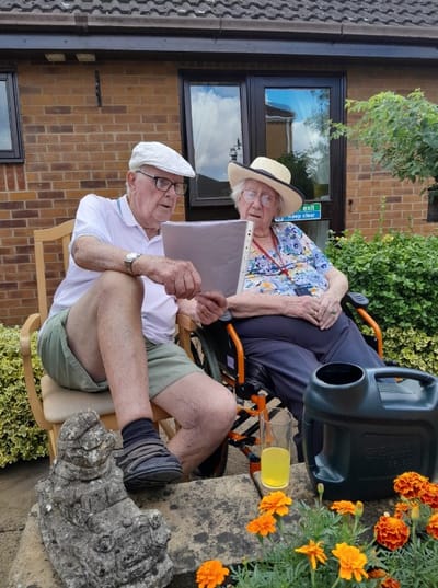 Two residents enjoying a conversation outdoors in a garden