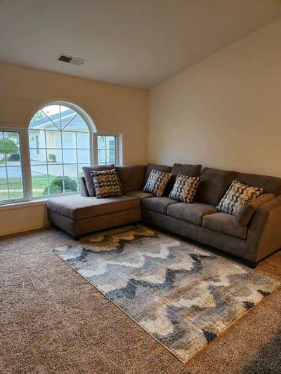 Cozy living area with a sectional couch and window