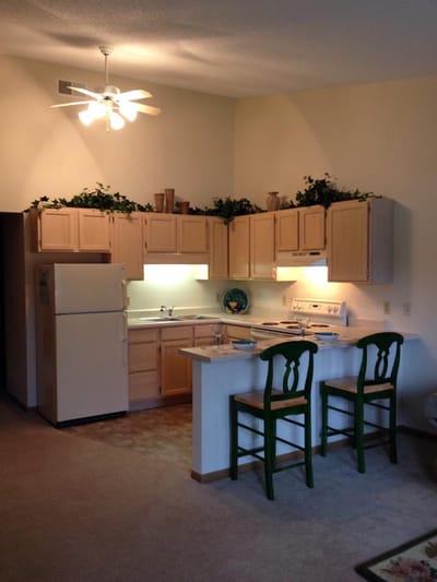 Bright kitchen area with wooden cabinets and bar stools