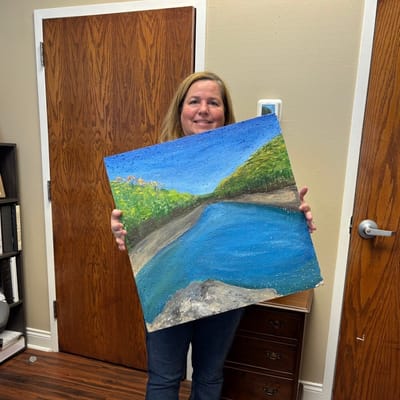 Staff member displaying an art piece in the facility