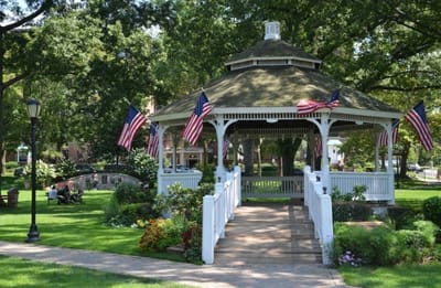 A gazebo in a park with American flags