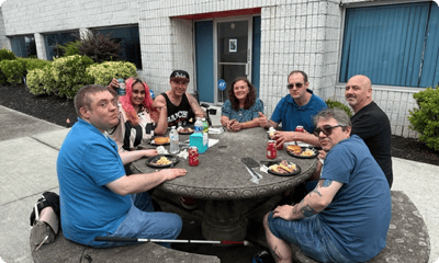 Residents enjoying a meal outdoors at a round table