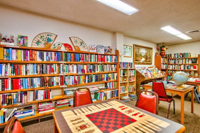 Interior view of a common area with bookshelves and game table