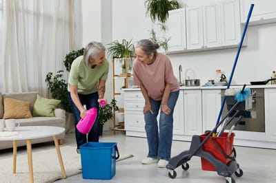 Two residents cleaning in a bright common area