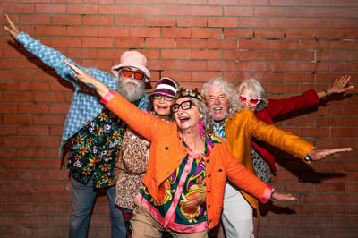 Group of residents celebrating together in colorful outfits.