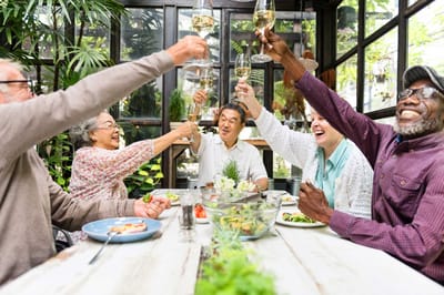 Residents and staff toasting with glasses in a bright common area