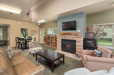 Common area in a senior living facility with seating and a fireplace