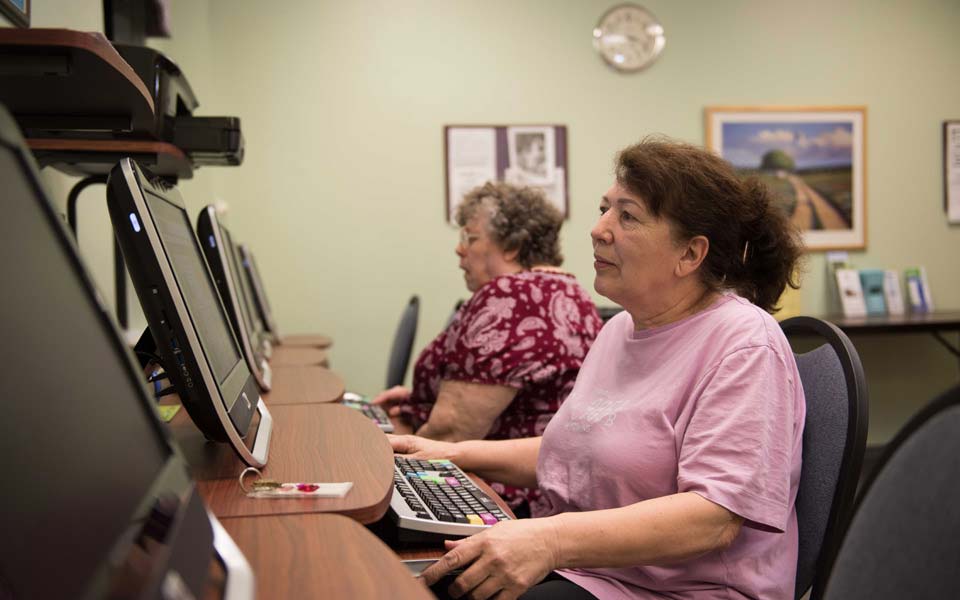 Residents using computers in an activity room