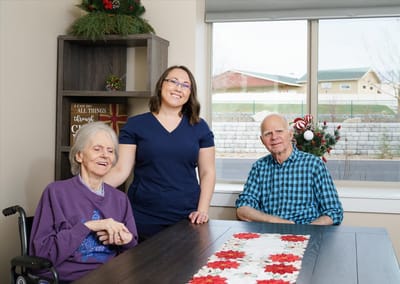 Residents and staff smiling together at a table