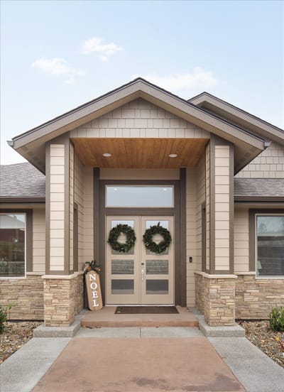 Front entrance of a senior care facility decorated for the holiday