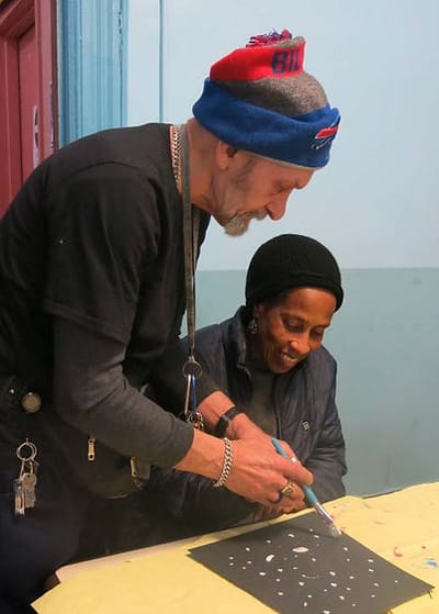 An instructor and a resident engaged in an arts and crafts activity.