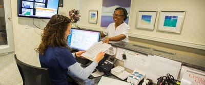 Staff assisting a resident at the reception desk