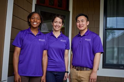 Staff members posing outside a senior care facility