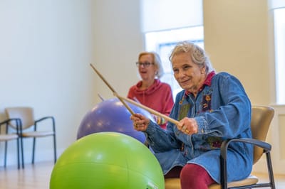 Residents engaging in a chair exercise class with fitness balls