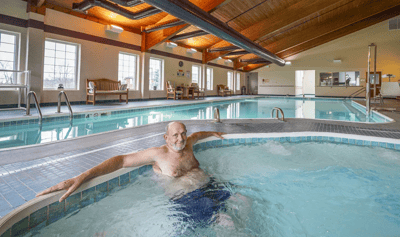 A senior man enjoying a swimming pool spa area