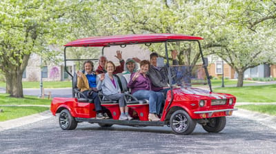 Residents enjoying a ride in a red golf cart