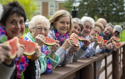 Residents enjoying watermelon outdoors at a summer event