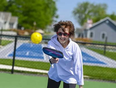 Resident enjoying a game of pickleball outdoors