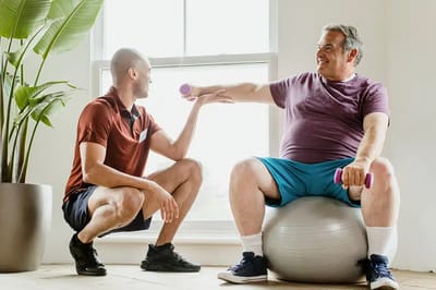 Senior resident exercising with staff assistance