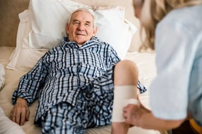 Healthcare worker attending to a male resident in a room