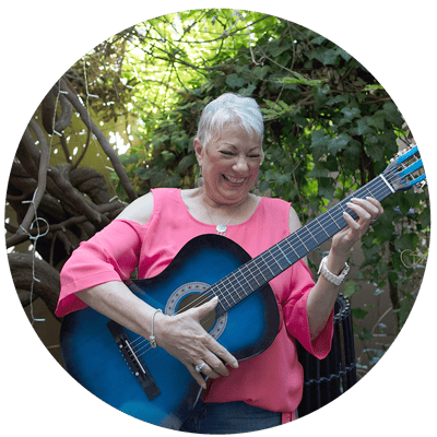 Resident playing guitar in a garden area