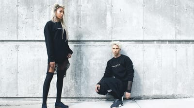 Fashion models posing against a concrete wall
