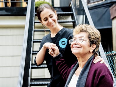 Staff assisting a senior resident outdoors