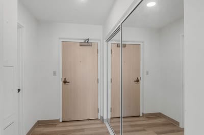 Interior view of a residential entryway with mirrored closet doors