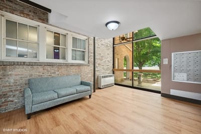 Bright interior common area with a couch and windows